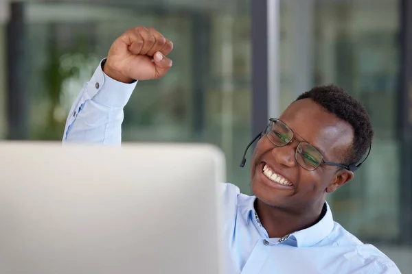 Winner, computer and call center with a black man cheering as a consultant in his customer service office. Success, sale and motivation with a happy young male support agent in a crm workplace.