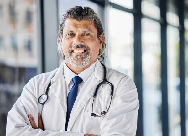 Doctor, healthcare portrait and arms crossed in clinic or hospital of patient support, leadership or management. Face of senior medical person with professional health services and proud job.