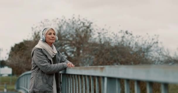 Most Starší Žena Sluchátka Hudbou Myšlení Venku Výhledem Starší Žena — Stock video