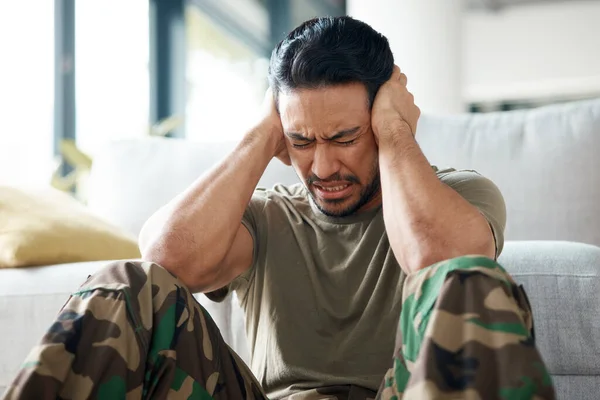 Soldier, man and stress, headache or PTSD of military trauma, remember pain and fear or scared on floor. Sad, frustrated and mental health of army or veteran person with depression or anxiety at home.