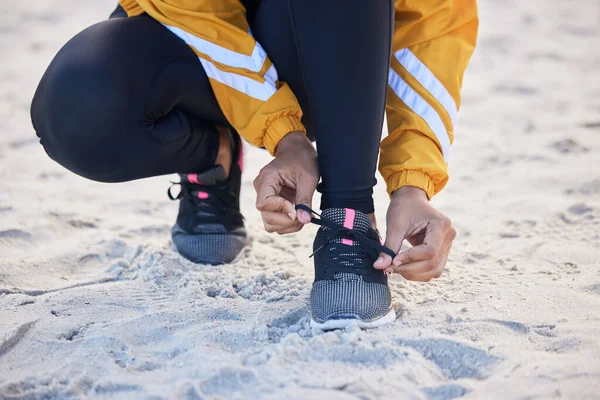 Beach, closeup and woman tie shoes for an outdoor run for fitness, health and wellness by seaside. Sports, athlete and zoom of female runner tying laces for a cardio workout or exercise by the ocean