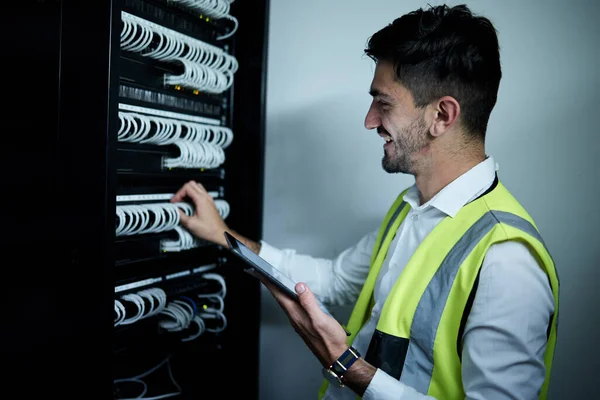 Technician, check server cables and tablet with system, happy or maintenance on web app in night. IT expert man, engineer and digital touchscreen for inspection, idea or smile in room for data center.