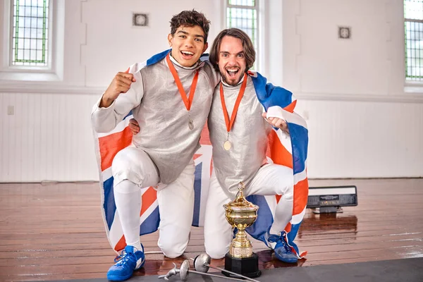 イギリスの国旗 フェンシング 試合に勝つためのトロフィーを持つ男性の肖像画 スポーツ 剣の戦い 興奮する男性アスリートは ゲームやトーナメントの賞を祝います — ストック写真