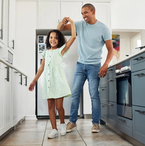 Love, kitchen and dad dancing with kid in a in a home for care, happiness and bonding together in a house. Laughing, parent and father playing with girl or child as support spinning with energy.