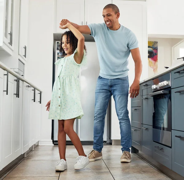 Love, kitchen and father dancing with child in a in a home for care, happiness and bonding together in a house. Laughing, parent and dad playing with girl or kid as support spinning with energy.