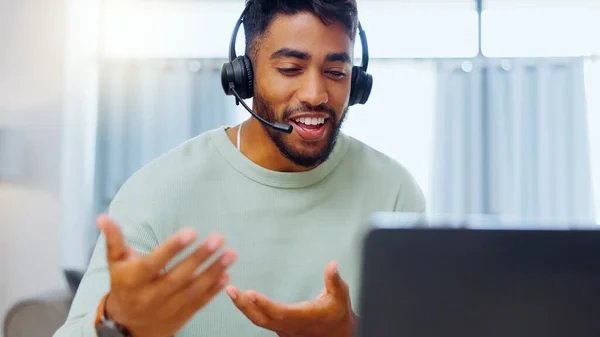 Video call, black man and work from home, virtual communication or remote client tech support in call center career. Hello, wave of indian person, agent or consultant in living room on laptop talking.