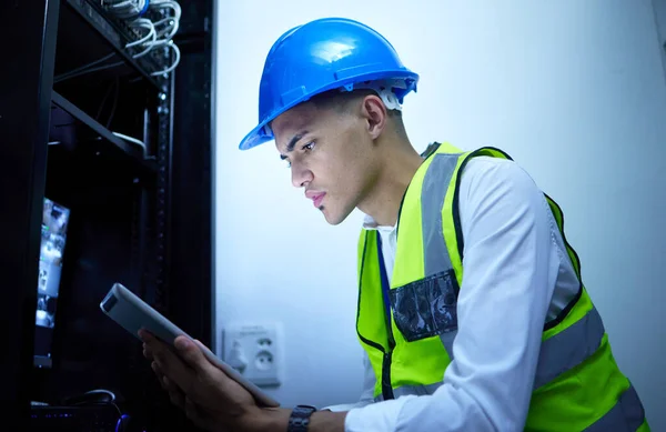 stock image Man, electrician and tablet for power maintenance, server room or data center upgrade in IT or cybersecurity. Young, engineering person on digital tech for network programming, electricity and cables.