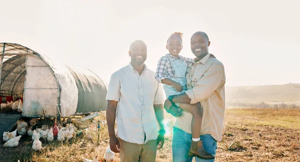 Happy, gay couple and portrait of black family on chicken farm for agriculture, environment and bonding. Relax, lgbtq and love with men and child farmer on countryside field for eggs, care or animals.