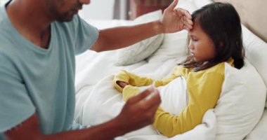 Hasta, termometre ve babası soğuk algınlığı ya da alerjisi olan çocuğunu yatakta kontrol ediyor. Hastalık, iyileşme ve baba, kızının ateşini evlerinin yatak odasında hissediyorlar.