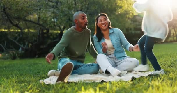 子供は一緒にピクニック中に屋外公園で両親と絆を結んでいる グリーンガーデンでリラックスしながら 彼女の若い母親と父親を受け入れるために走っている幸せ 笑顔と少女の子供 — ストック動画