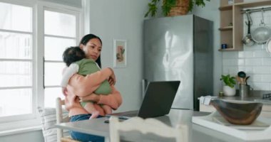 Laptop, uzaktan kumanda ve serbest girişimci olarak çalışırken bebeğini oturma odasında tutan bir anne. Bilgisayar, başlangıç ve tek ebeveyn. Küçük çocuğu mutfakta..