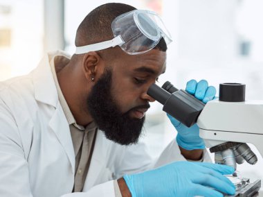 Mikroskop, tıp bilimi ve laboratuvarda araştırma, çalışma, analiz ya da odaklanma yapan bir adam. Yenilik, biyoteknoloji ve gelecekteki gelişim alanlarına sahip siyahi bir insan veya bilim adamının yüzü.