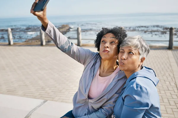 Senior fitness, selfie and women at the beach for workout, wellness and morning cardio in nature. Healthy retirement, social media and friends at sea for profile picture, photo or exercise memory.