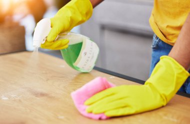 Masa, sprey ve el temizliği bir evde hijyen, mikrop koruması ve bakımı için bir kimyasalla birlikte. Bakteri, servis ve temizlikçi ya da temizlikçi Eldivenlerle ahşap bir masada çalışıyor.