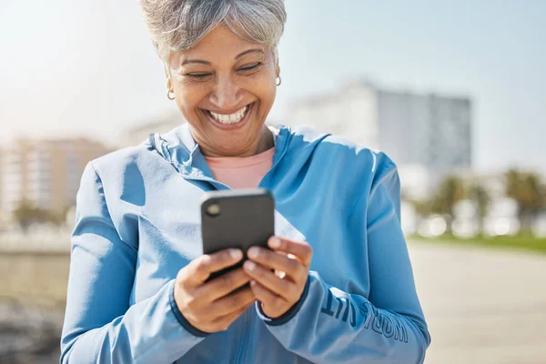 フィットネス 携帯電話を持つ屋外とシニアの女性 接続とタイピングとソーシャルメディア ネットワークと幸せ スマートフォン スマートフォン付きのハッピーパー 老婦人 健康との接触 — ストック写真