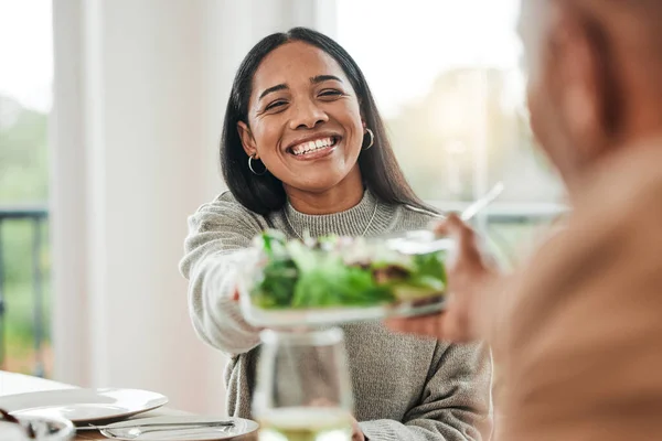 Happy woman, salad and family dinner at thanksgiving celebration at home. Food, female person and eating at a table with a smile from hosting, lunch and social gathering on holiday in dining room.