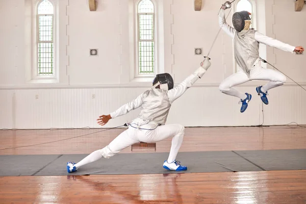 Fencing, exercise and people fight, jump and training, fitness or workout for energy with epee sword in club. Battle, fencer or athlete in performance, competition or sports with mask, helmet or suit.