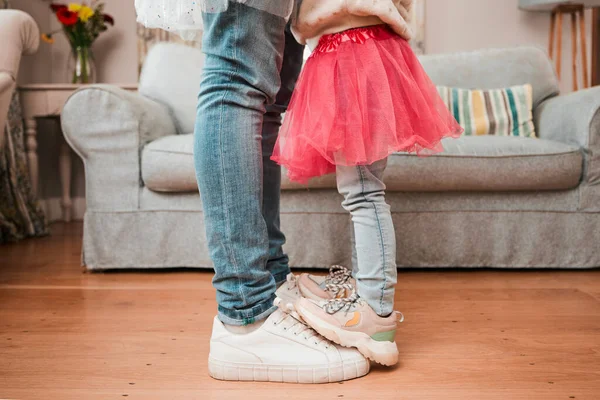 Dance, feet and home with father and daughter in living room for ballet, princess and love. Music, care and learning with closeup of man and child in family house for helping, youth and energy.