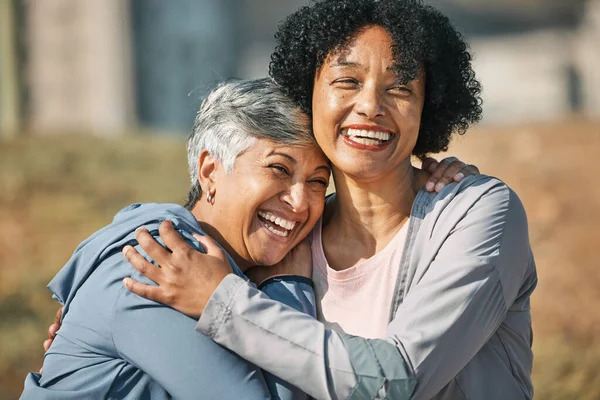 Senior women, hug and laugh closeup with fitness and exercise outdoor for health. Elderly people, sport training and happy friends with excited bonding and embrace after running of a mature athlete.