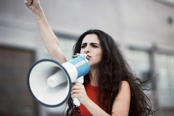 Megaphone, woman and shouting for social change, justice for equality and humanity with activist on street, stand up and strike. Young female, protester and girl with bullhorn, protesting for freedom.