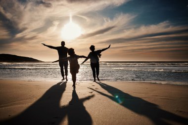 Aile, koşmak ve siluet plajda gün batımı, özgürlük ve birlikte eğlence, oyunlar ve tatilde kaynaşma. Seyahat, macera ve neşe dolu, doğada ve enerjide mutlu insanlar olan ebeveynler ve çocuklar..