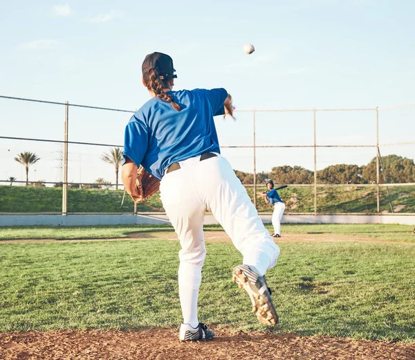 Baseball, pitching and a sports person outdoor on a pitch for performance or competition. Behind professional athlete or softball player with fitness, ball and throw for game, training or exercise.