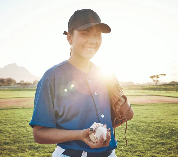Baseball, ball and portrait of a woman outdoor on a pitch for sports, performance and competition. Professional athlete or softball player with smile, fitness and ready for game, training or exercise.