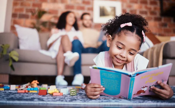Child, toys and reading in home with knowledge development and building block in living room. Family, fun and youth learning with a young girl and parents in a house together with care and bonding.