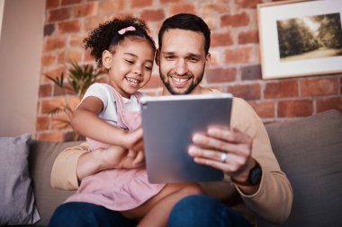 Baba, çocuk ve tablet, aile evindeki kanepede ya da internetten öğrenme, eğitim için oyun ya da teknoloji oynama. Baba, çocuk ve mobil uygulama öğretmek ya da çizgi film izlemek ve rahatlamak için televizyon izlerken.