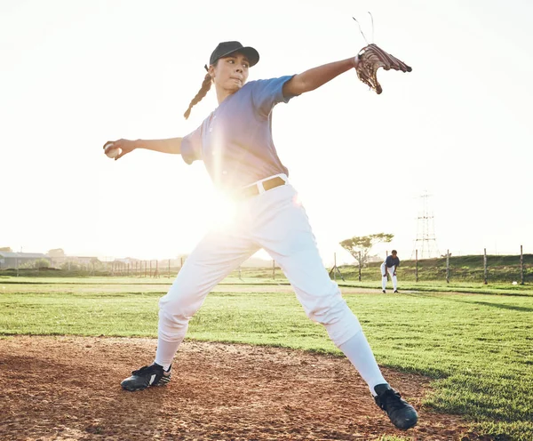 Pitching a ball, baseball and person outdoor on a pitch for sports, performance and competition. Professional athlete or softball player for a game, training or exercise challenge at field or stadium.