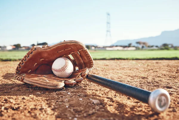 Glove, bat and baseball gear on the sand for a game, professional competition or sports. Ground, fitness and equipment for a match, fitness or training for softball on the sand in summer for cardio.