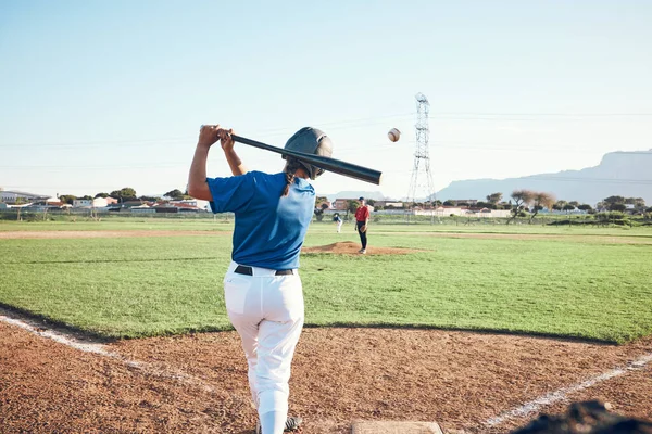 Baseball, bat and person swing at ball outdoor on a pitch for sports, performance and competition. Behind athlete or softball player ready for game, training or exercise challenge at field or stadium.