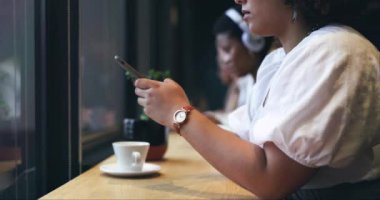 Kafe, telefon ve internet ya da sosyal medyada mesaj yazan bir kadının yakınlaşması. Teknoloji, bir fincan kahve ve bir restoranda araştırma yapan ya da cep telefonunu karıştıran genç bir kadın..