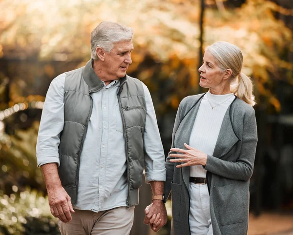 Love, park or couple holding hands, walking and enjoy time together, relax conversation and nature. Wellness, marriage and elderly people on romantic date, outdoor freedom or talking about retirement.