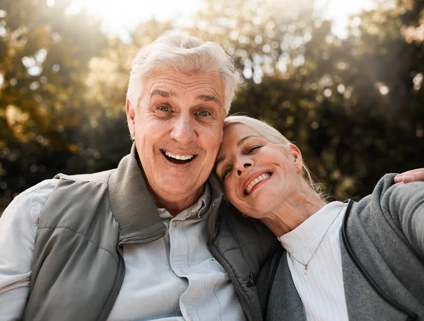 Happy, portrait and senior couple hug in a forest, love and bond in nature on a weekend trip together. Smile, face and romantic old woman embrace elderly male in woods, cheerful and enjoy retirement.