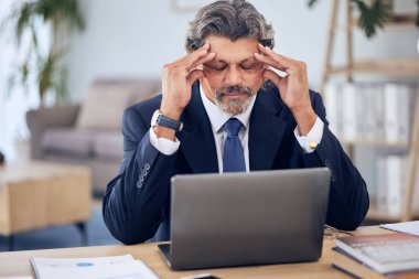 Stres, baş ağrısı ve bir şirket projesi üzerinde çalışırken iş adamının ofiste dizüstü bilgisayarı. Migren, tükenmiş ve olgun profesyonel erkek avukat iş yerindeki bir bilgisayarda araştırma yapıyor.