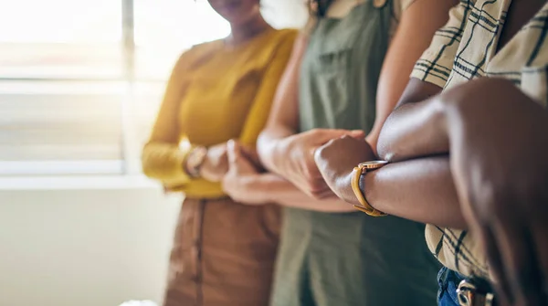 Holding hands, arms crossed and unity with business women in a row for equality or empowerment. Support, teamwork or collaboration with a creative employee group in the office for partnership closeup.