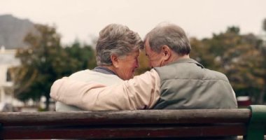 Sevgi, şefkat ve yaşlı çift bir bankta bağlılık, bağlılık ya da bahçede bakım için sarılıyorlar. Doğa, mutlu ve yaşlı bir adam ve kadın emekliliklerinde parkta samimi bir an için kucaklaşıyorlar..