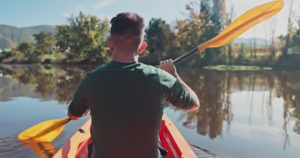 カヤック バックビューの男は 自然の中でキャンプしながら漕いで水を探索する冒険に 自由のための田舎の休暇や休暇のための湖のボート カヌー — ストック動画