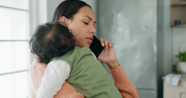 マルチタスク そしてコミュニケーションやネットワーキングのために自宅のリビングルームに赤ちゃんを抱えている女性 キッチンで幼い子供とモバイル 若いシングルマザー — ストック動画