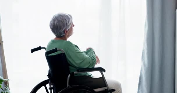 老年人 妇女和在家中坐在轮椅上思考 为退休的残疾人放松身心 回忆和年老的女性孤独地坐在窗前或回忆着一场梦 — 图库视频影像