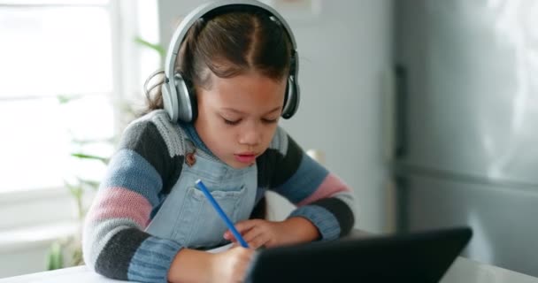 ホームワーク ヘッドフォンを持つ子供 テストを書いたり 仮想教室のためのタブレットで学習 オンラインクラスプロジェクトのためのキッチンでホームスクールを持つ学習 スマートガール — ストック動画