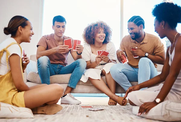 Game, laughing or friends playing cards, poker or black jack at home gambling together in a holiday party. Happy people, men or group of funny women relax in living room in a fun match competition.