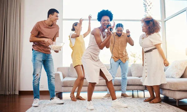 音乐和朋友们在客厅里用麦克风 播放机或收音机做卡拉Ok 多元和年轻人在家里跳舞 打情骂俏 在一起娱乐 — 图库照片