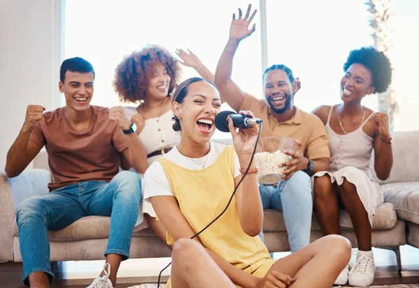 Microphone, happy people or friends singing in home living room together in a party on holiday vacation break. Girl singer, men or group of funny women laughing in a fun karaoke celebration or game.