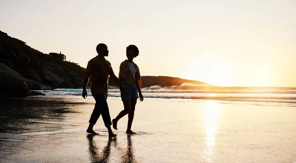 ビーチ サンセット シルエットのカップルは砂の上を歩き 手を握り 一緒にロマンチックな時間を楽しんでいます ウェルネス 夏の自由 そしてつながる人々の暗い影 トロピカルデートで話し リラックス — ストック写真