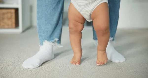 Legs, baby learning to walk with parents and growth, development and early childhood with motor skills. Family, support and first steps with trust, progress and balance with milestone and feet.