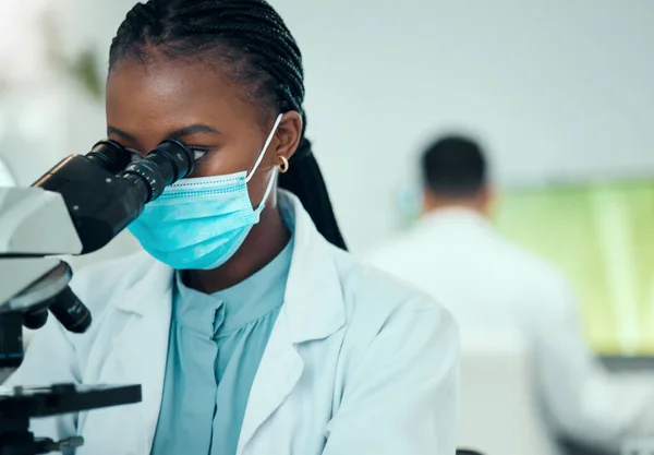 顕微鏡 女性科学者 医薬品研究室で顔面マスクを施した バイオテクノロジー機器を用いたウイルス研究に携わるプロフェッショナル 科学的 アフリカの女性研究者 — ストック写真
