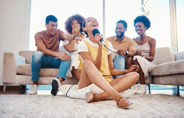 Microphone, relax or friends singing in home living room together in a party on holiday vacation break. Girl singer, happy men or group of funny women laughing in a fun karaoke competition or game.