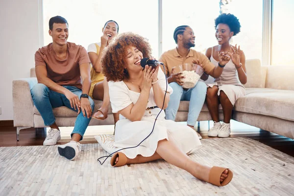 Mic, happy people or woman singer in home living room together in a party on holiday vacation break. Girl singing, excited men or group of funny women laughing in a fun karaoke celebration or game.